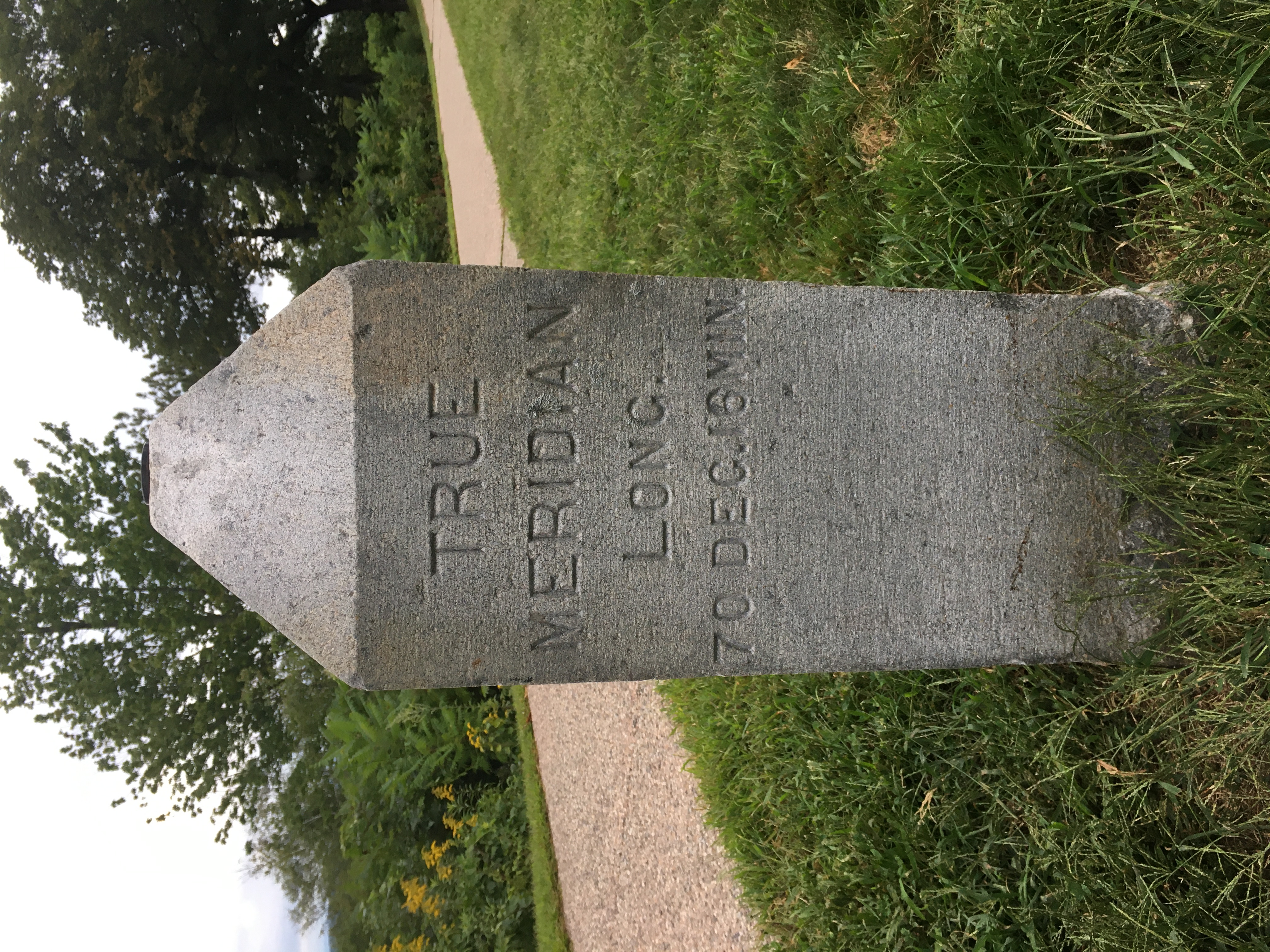 a stone obelisk that had the survey marker on top. The side reads "True Meridian Long. 70 dec. 16 min. 