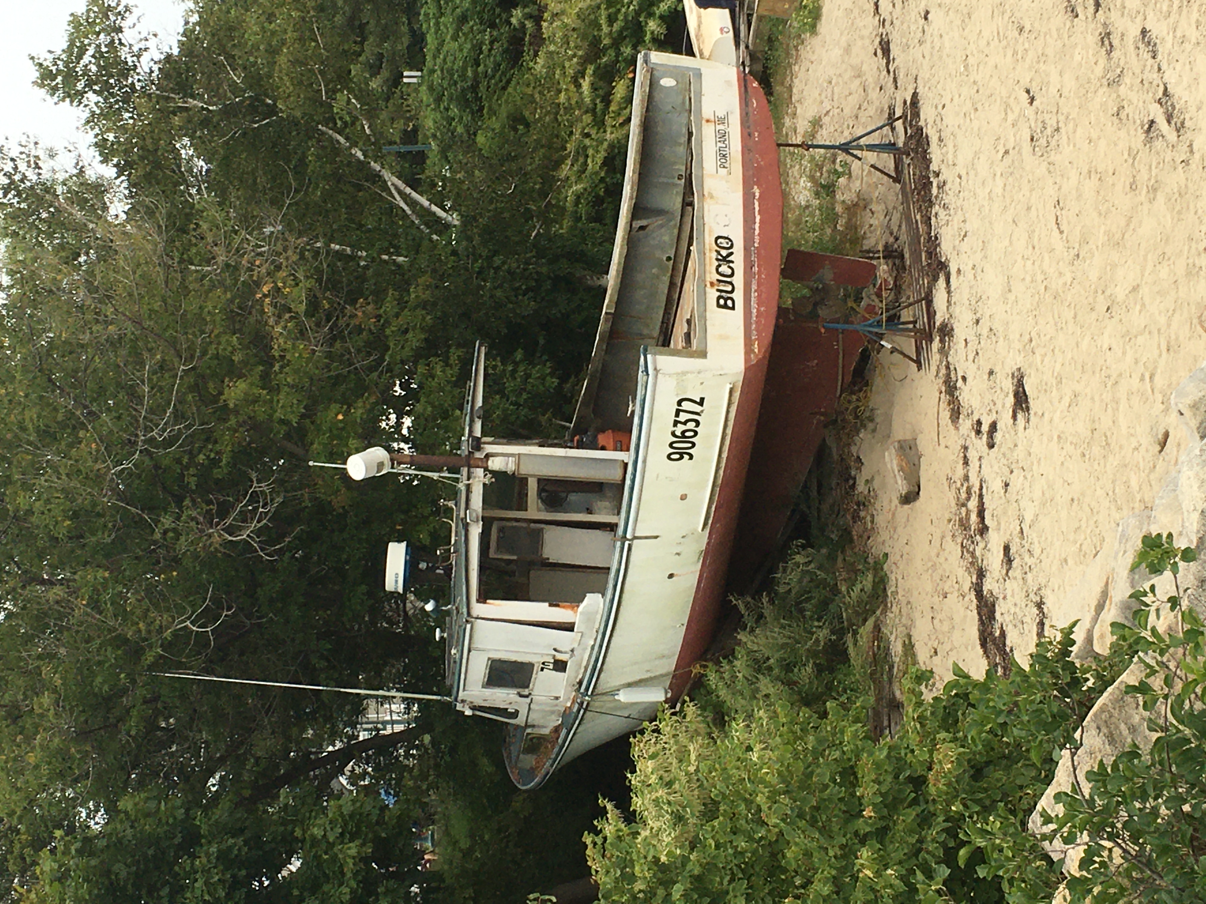 Old boat on the sands at the shore. It's name is Bucko