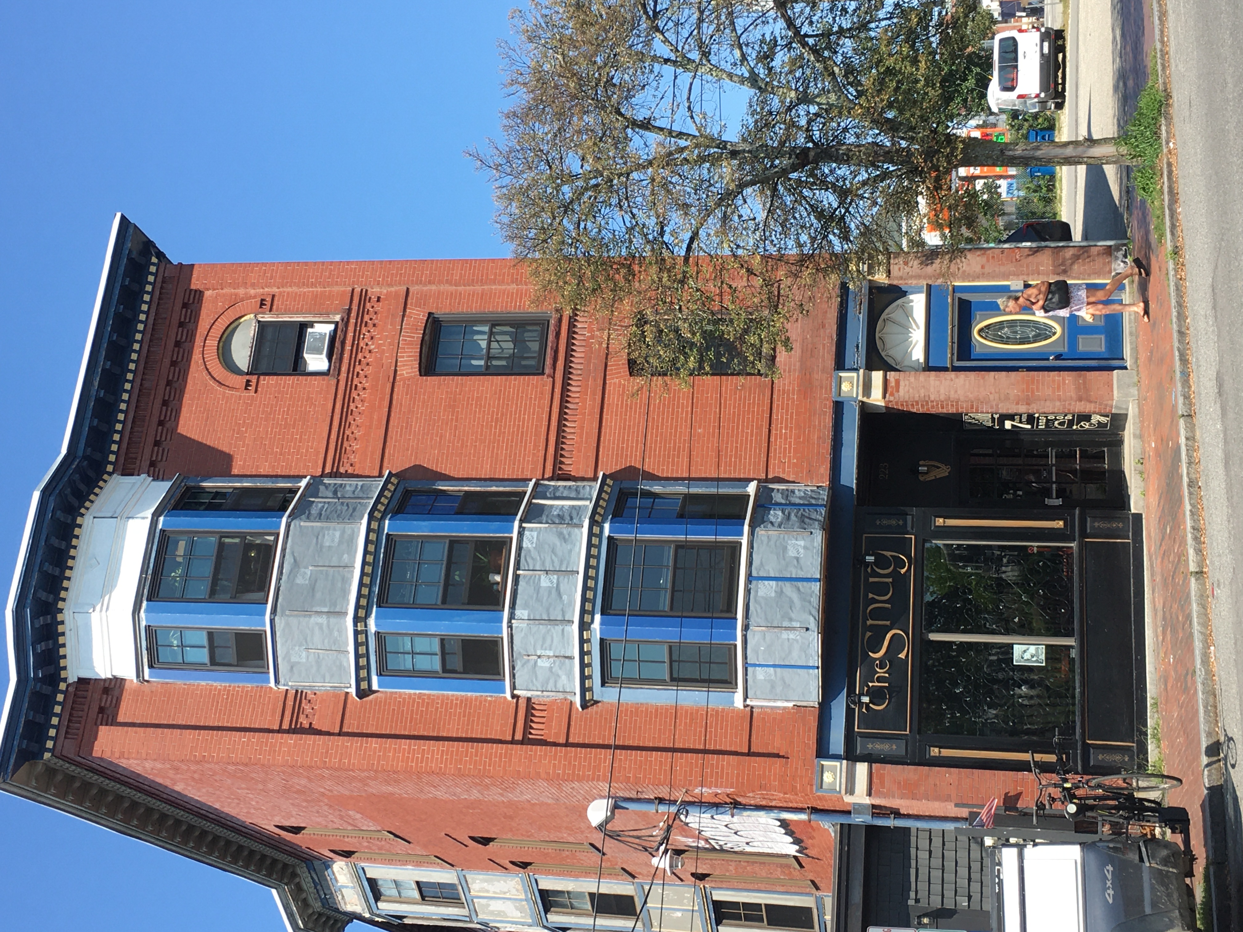 A victorian brick building with a sign for "The Snug" at the bottom it's a pub