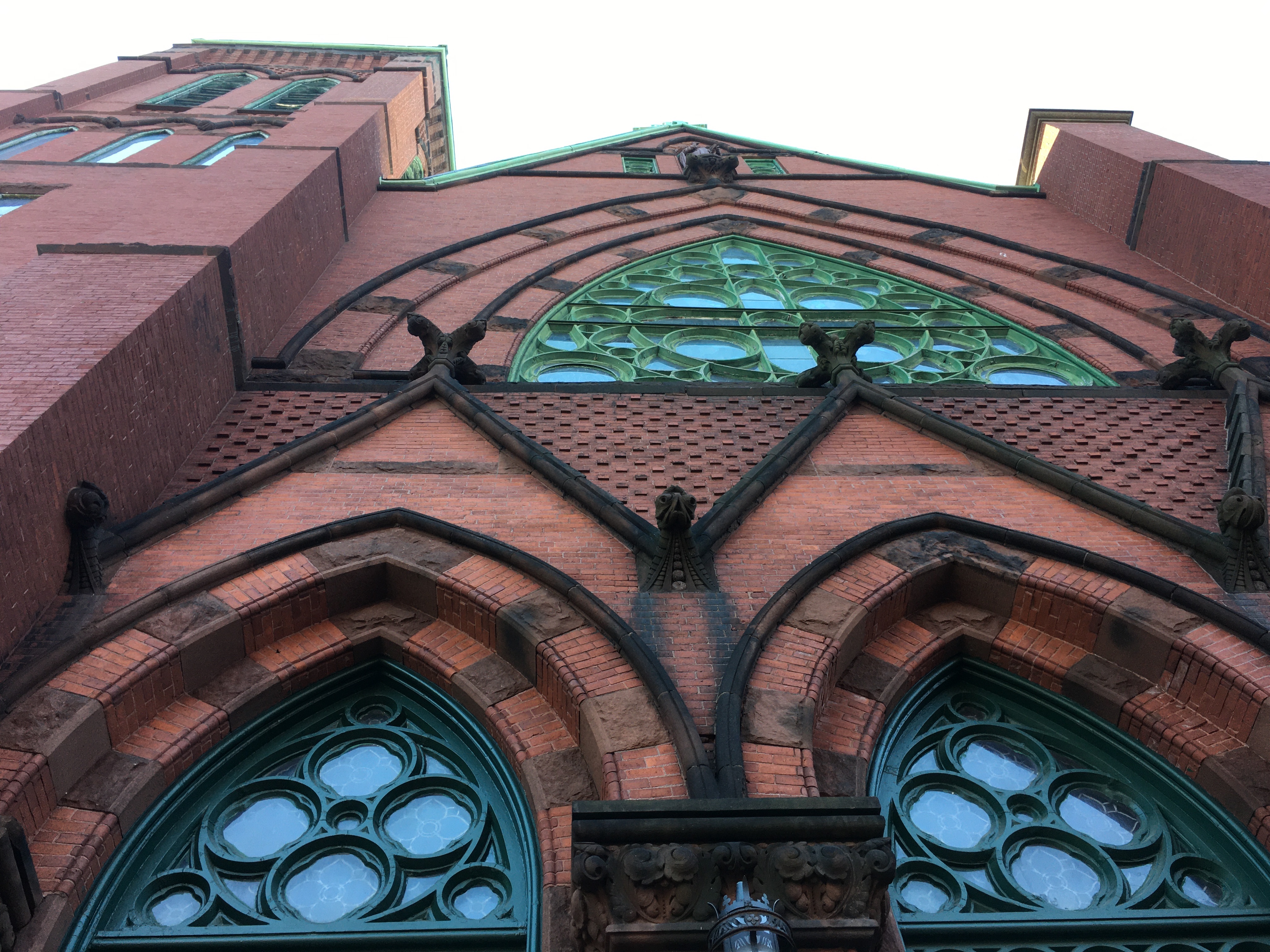 an elaborate brick buildings with green window trim likely a church