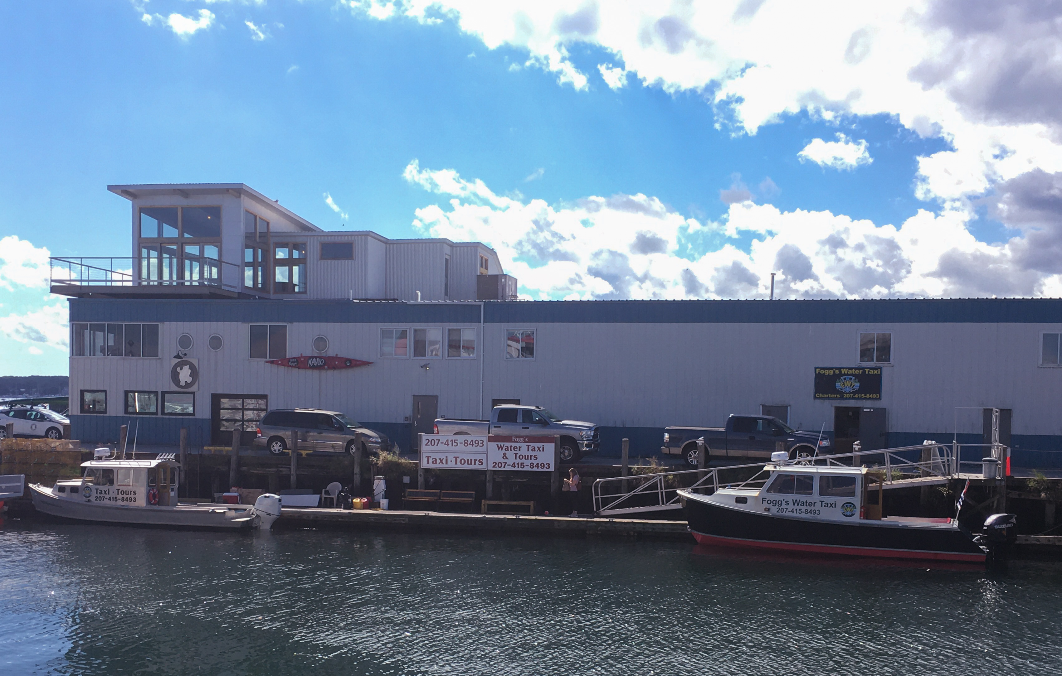 A sign and two boats that say Fogg's water taxi service