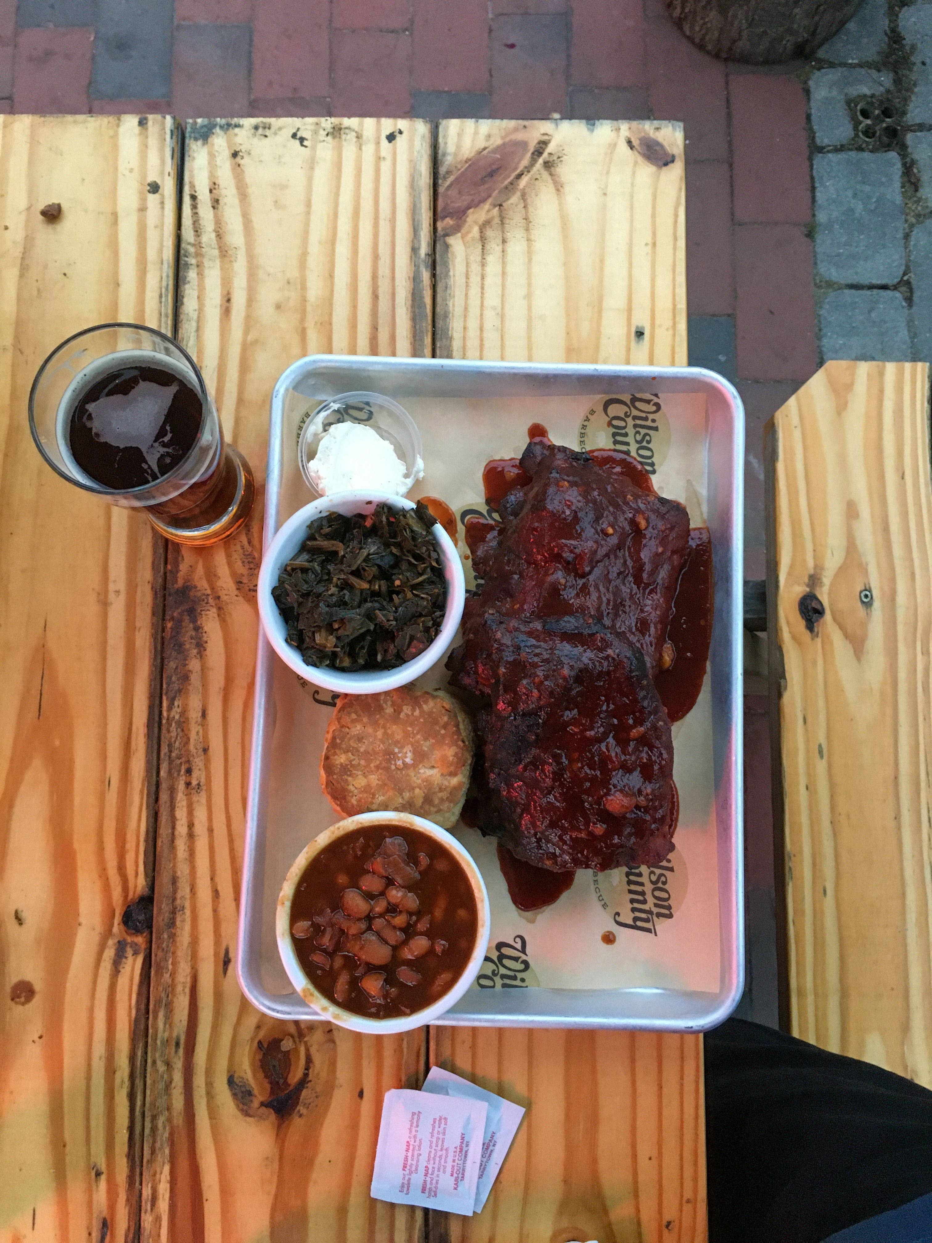 ribs, baked beans, collards on a cafeteria tray