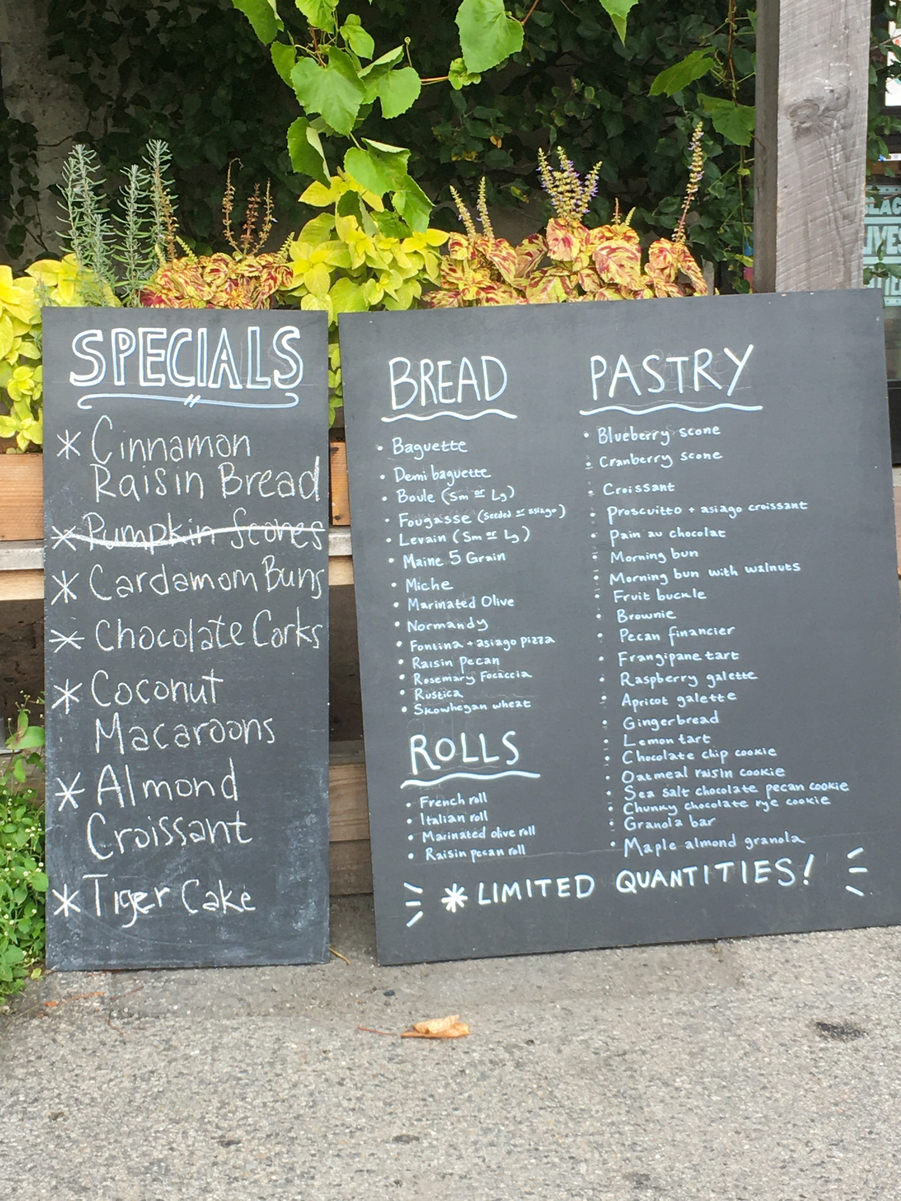 menu of pastries and bread on a chalk board