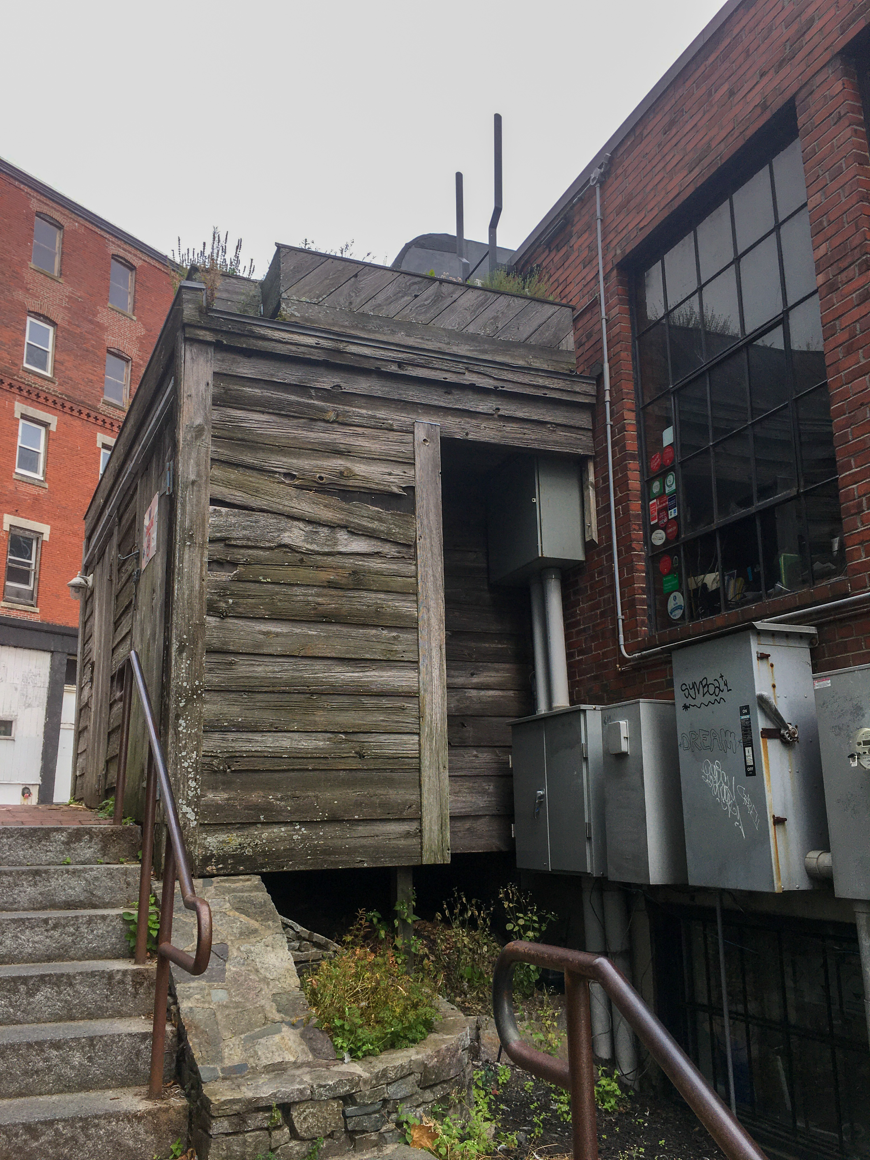 old decrepit wood building on in amongst brick