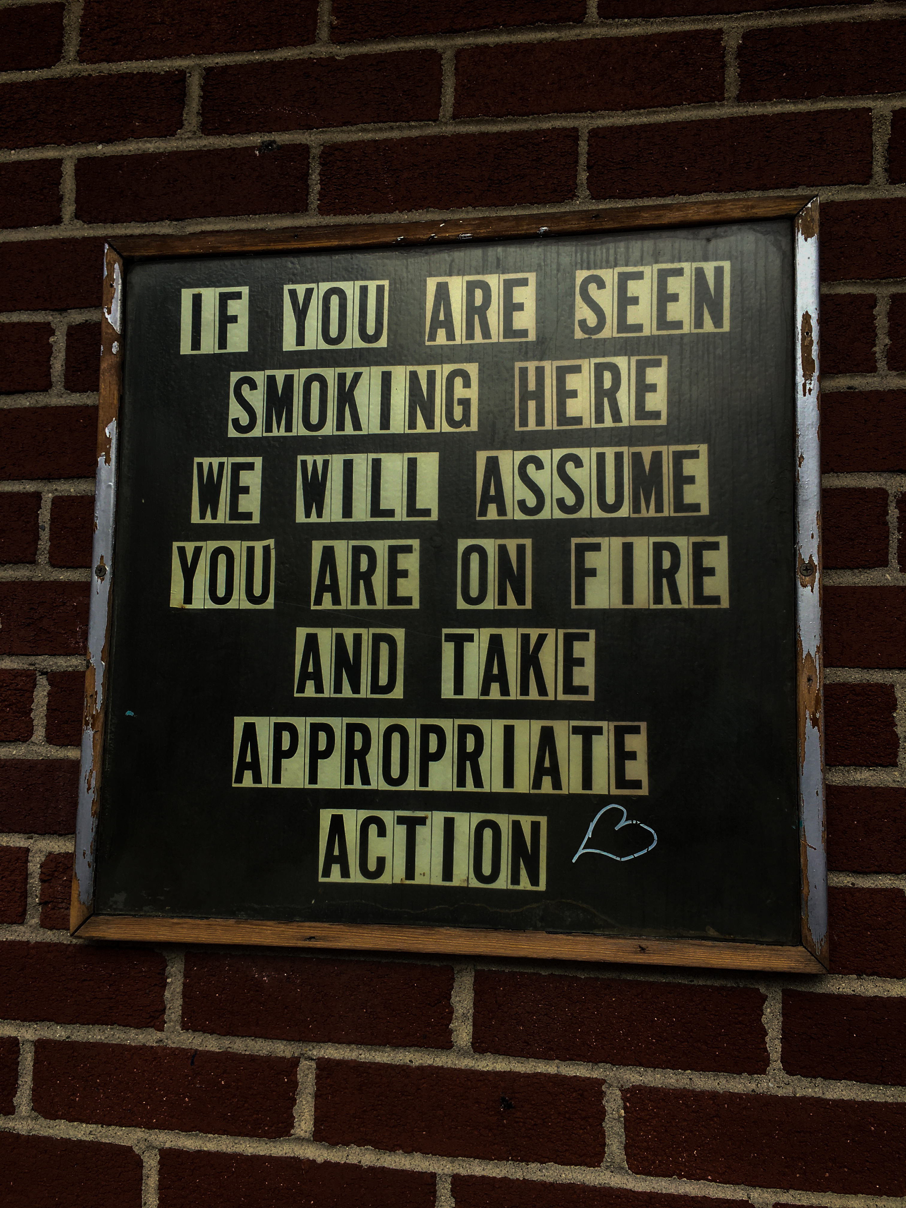 Sign that says: "If you are seen smoking here we will assume you are on fire and take appropriate action