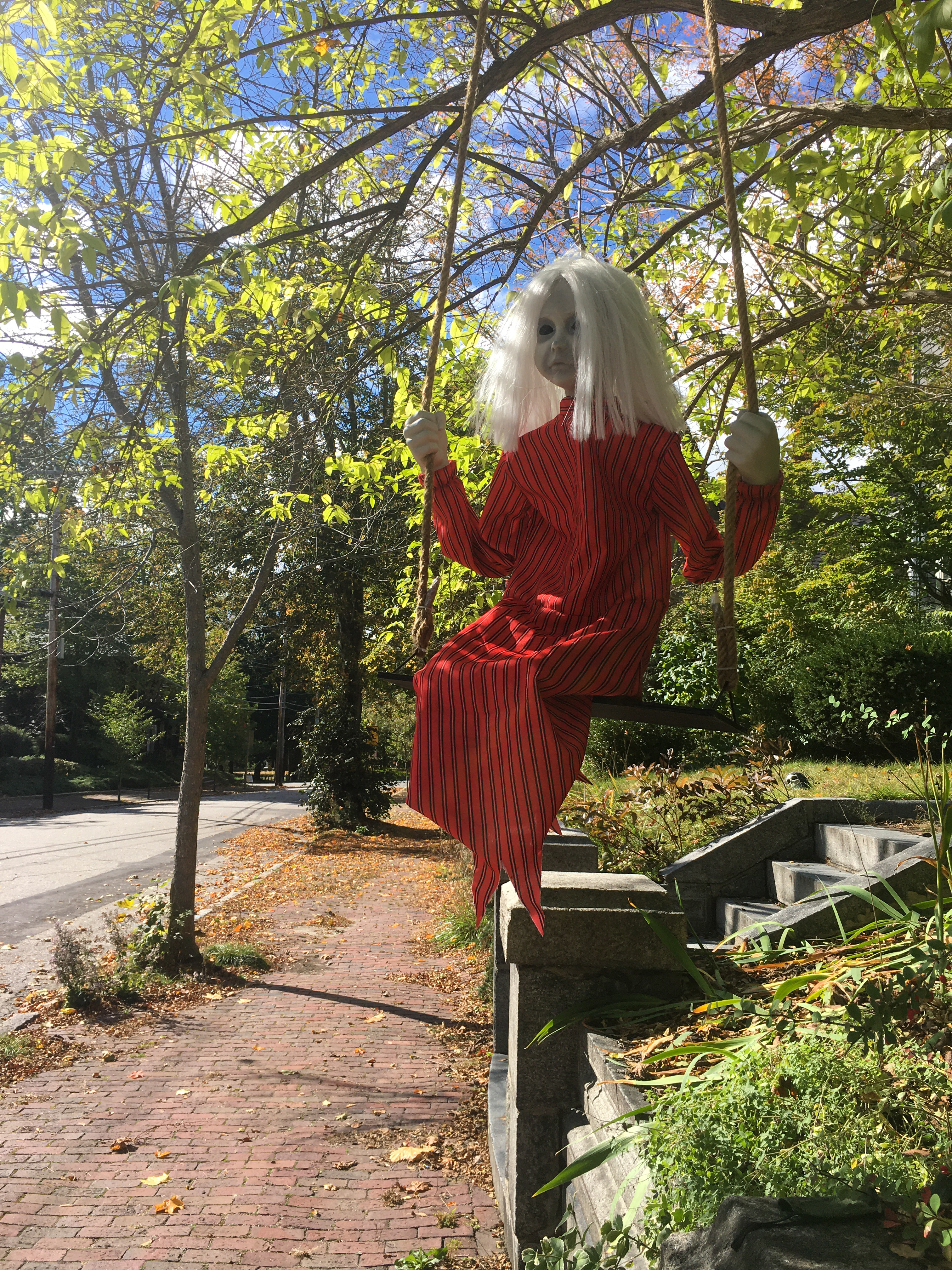 doll in a swing that looks haunted in red dress with no eyes