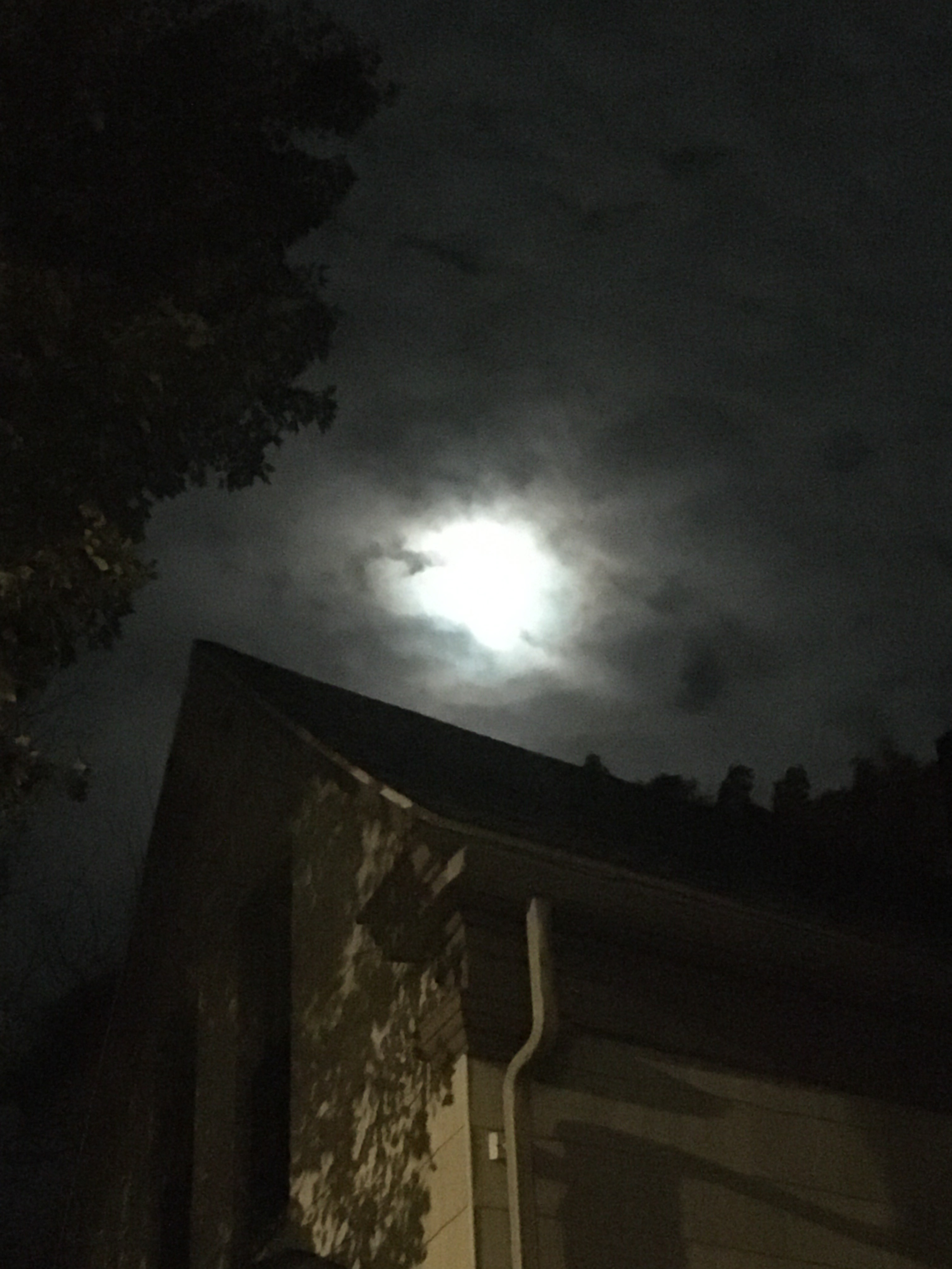 moon with clouds and vague outline of a house