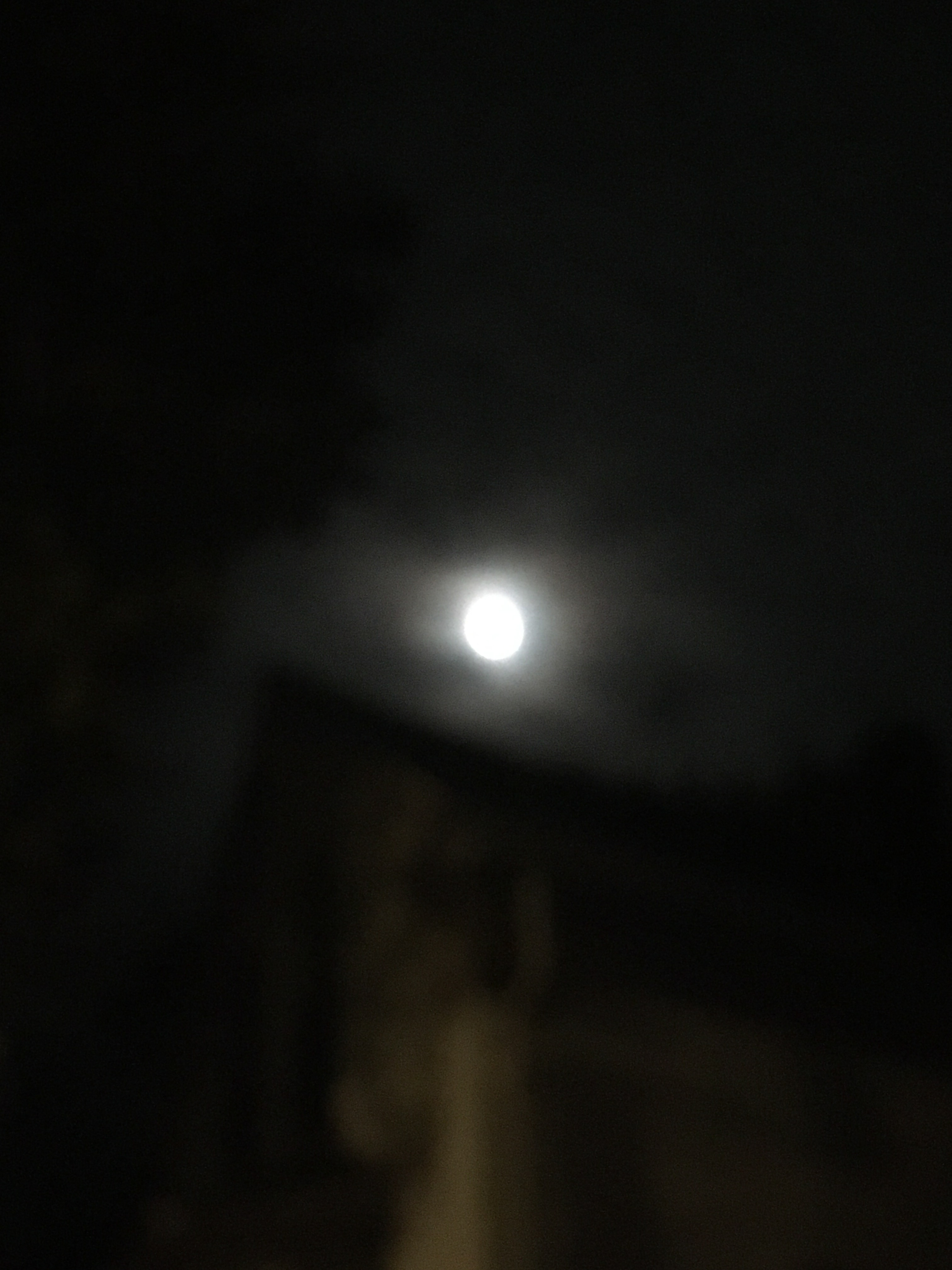moon picture against a dark sky with a faint image of a building