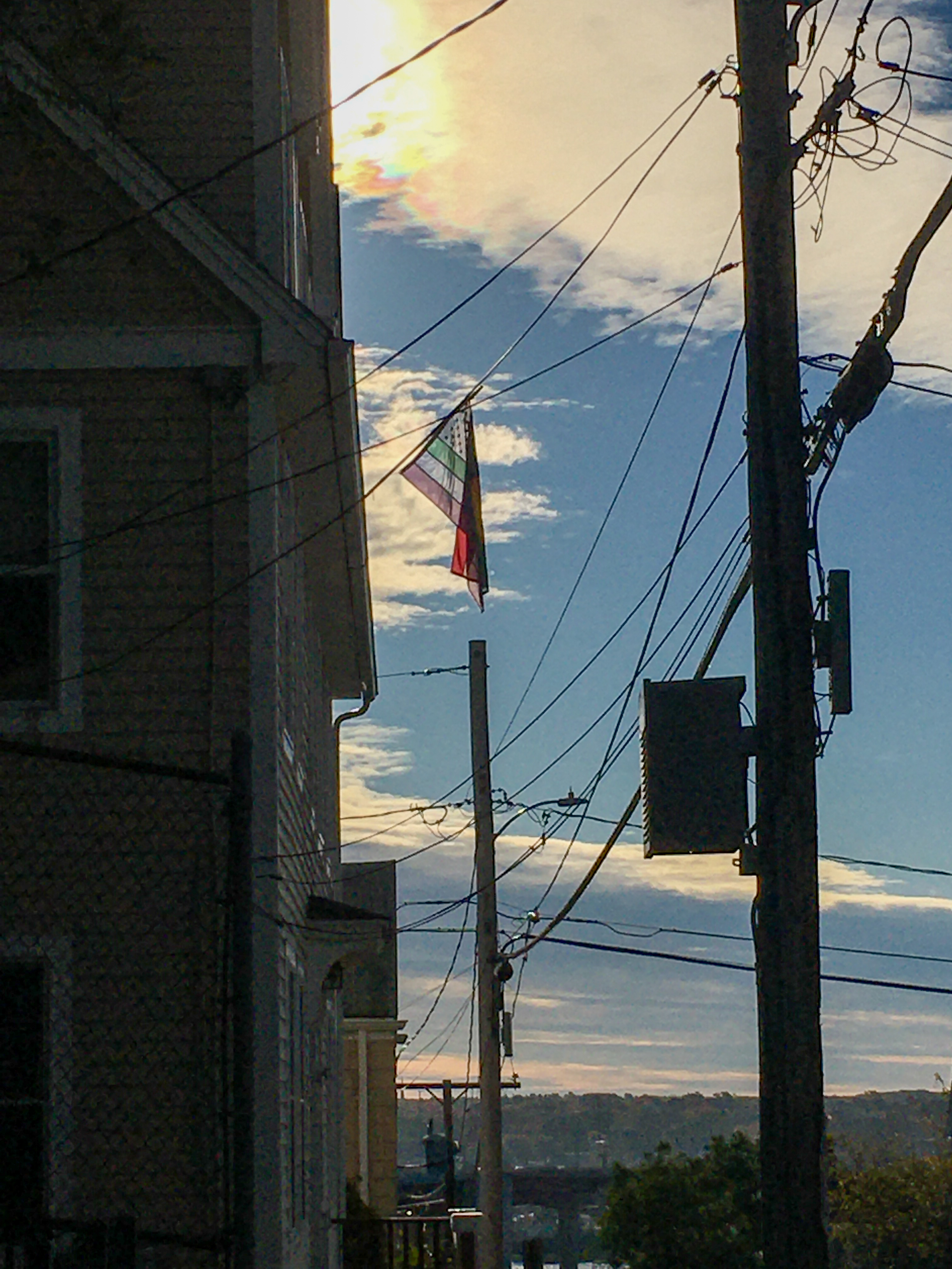 rainbow flat against a blue sky with telephone wires