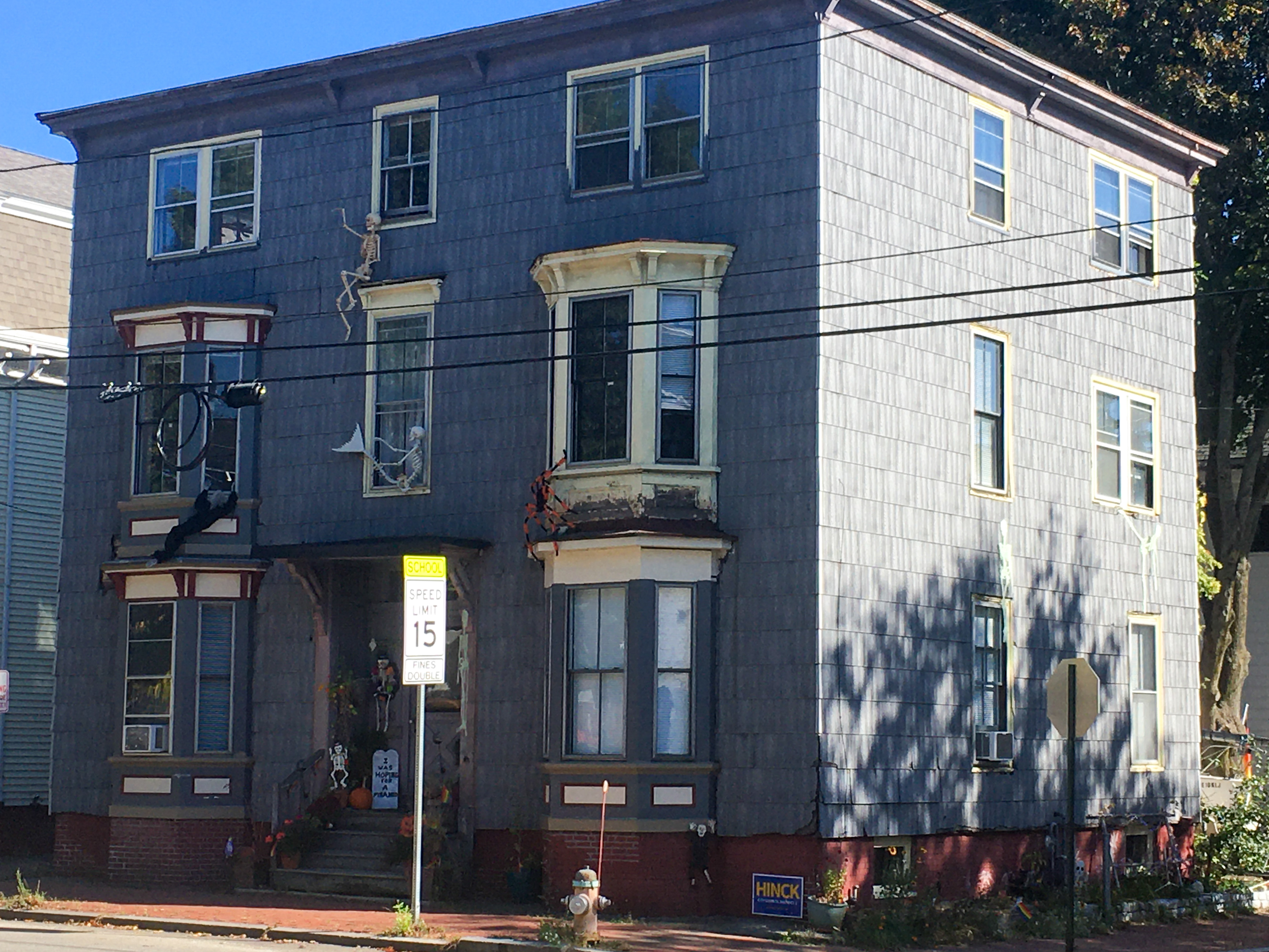 gray multi-family house with many halloween decorations