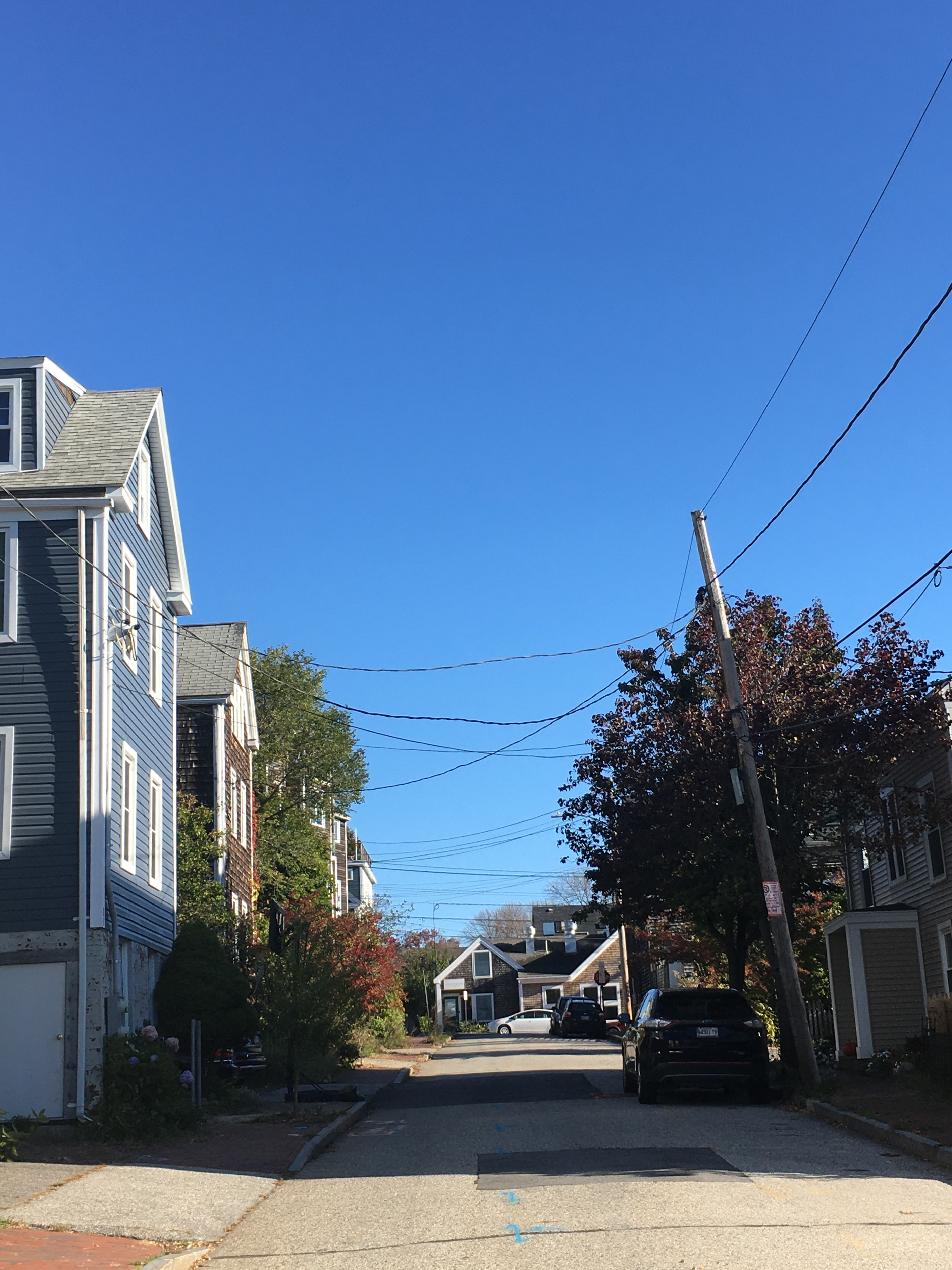 view up a residential street with trees and blue sky