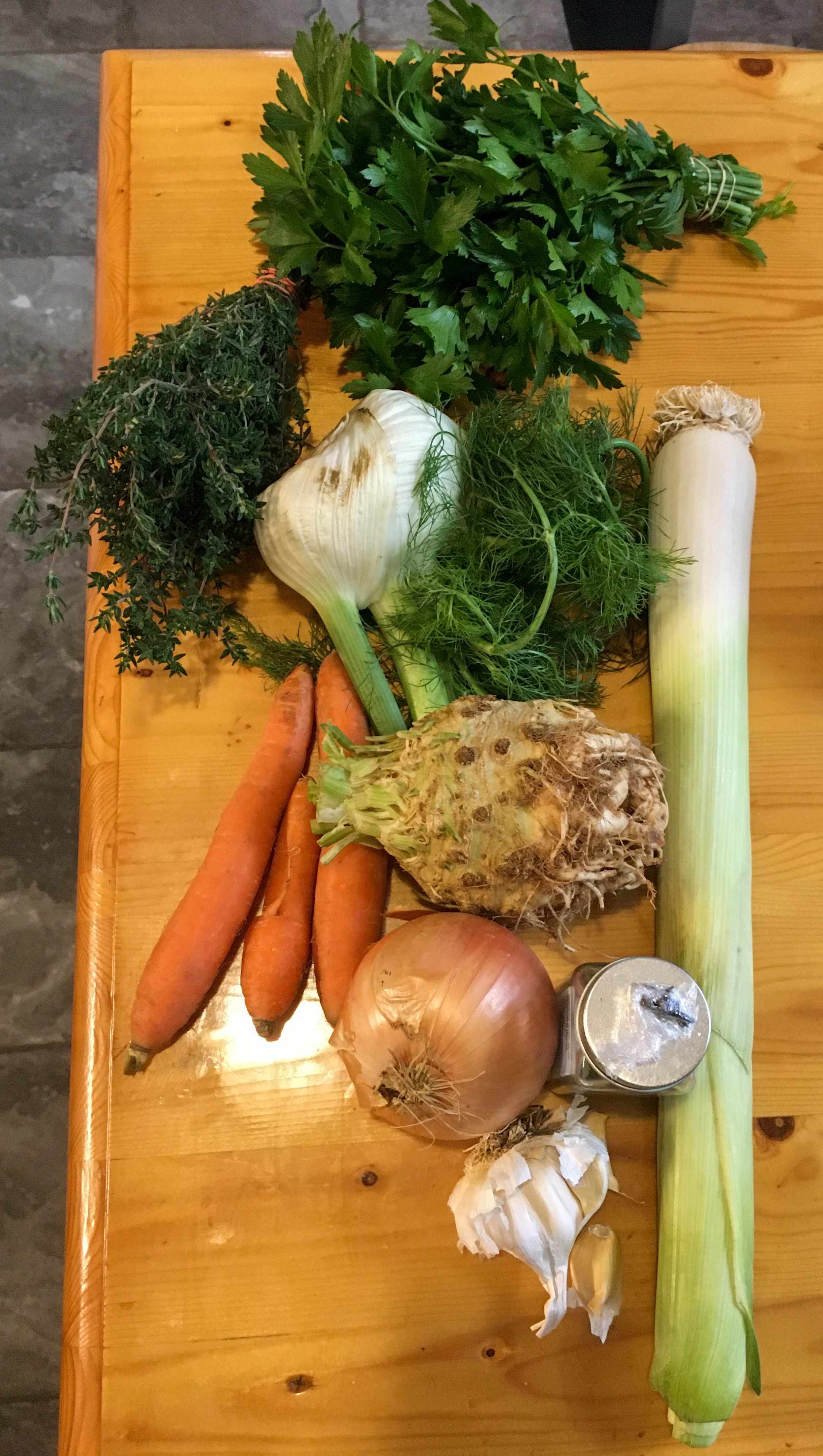 celery root, leek, fennel, carrots, onion, garlic, parsley and thyme on a table