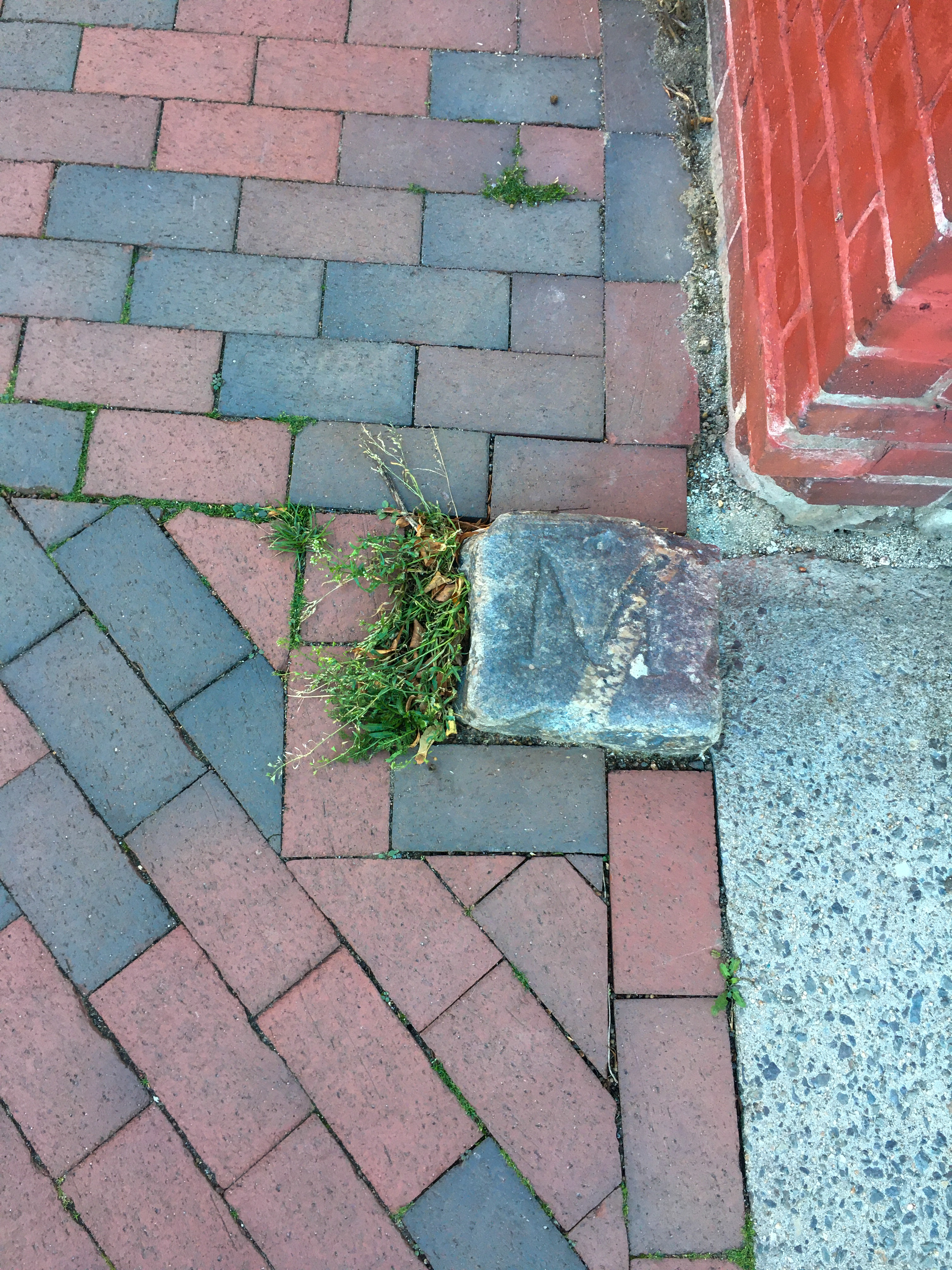 granite carriage block with the letter M on it