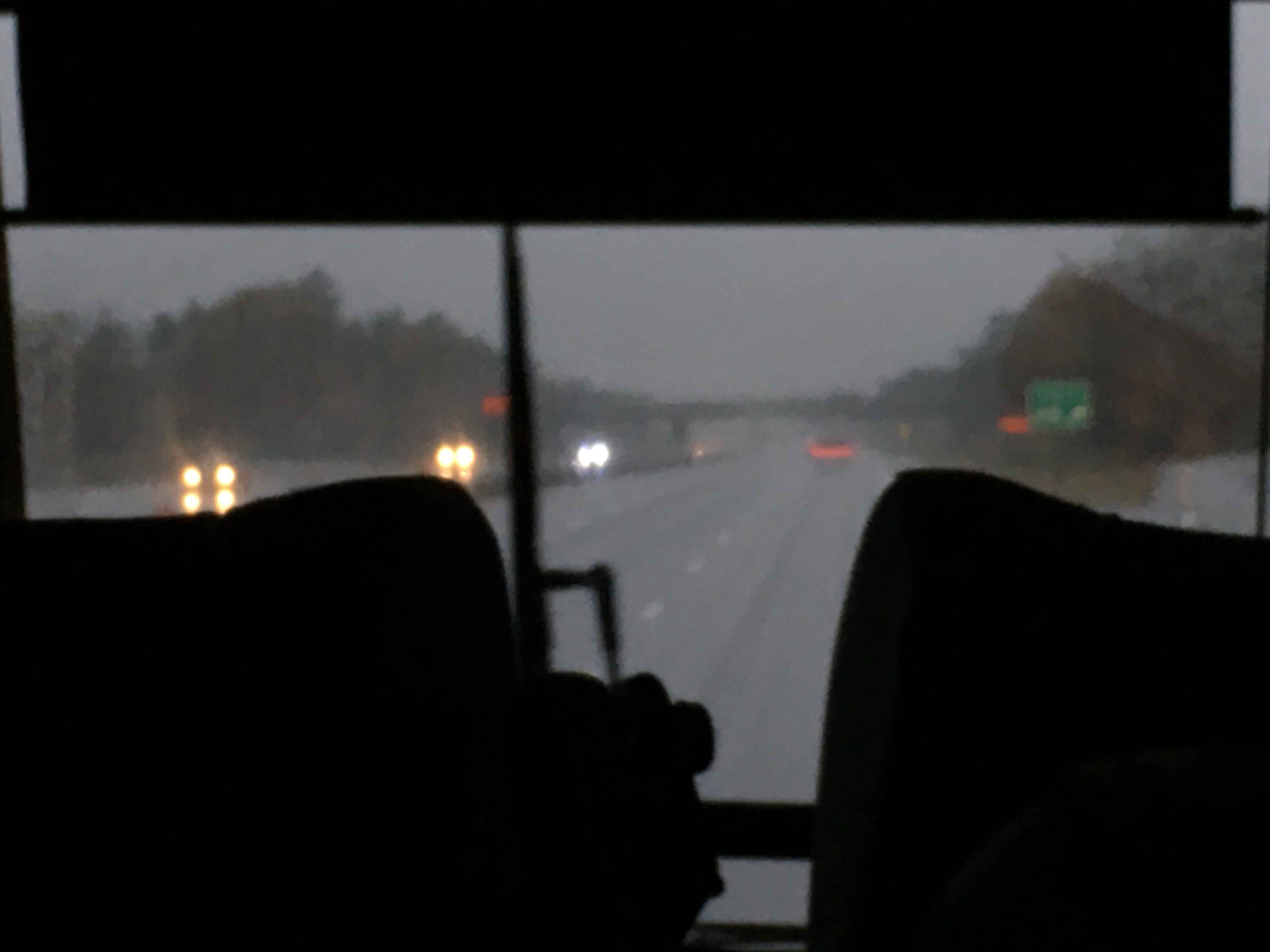 view through the front of a bus with windshield wipers working 