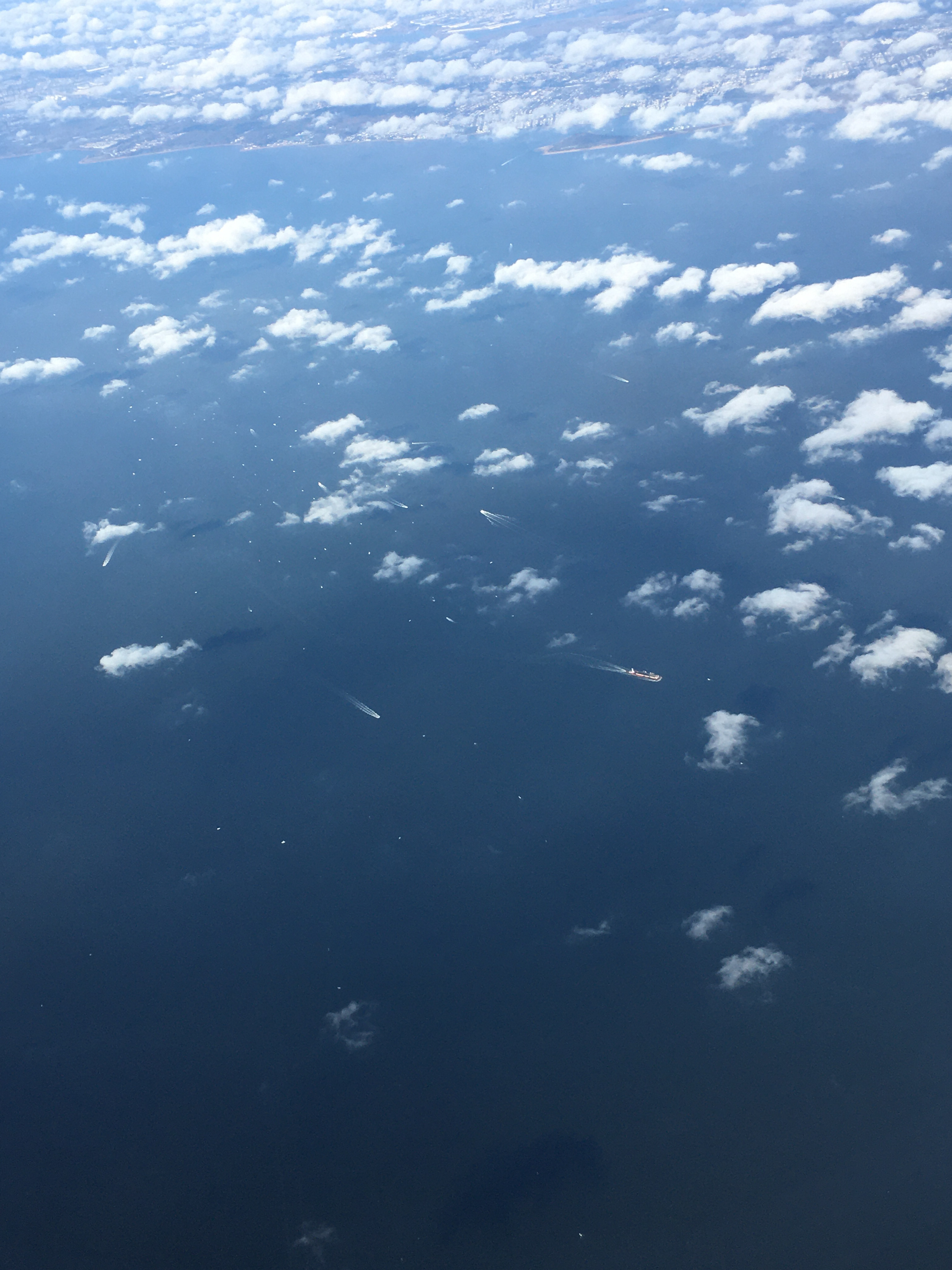 image of the sea with boats racing looking down on the clouds