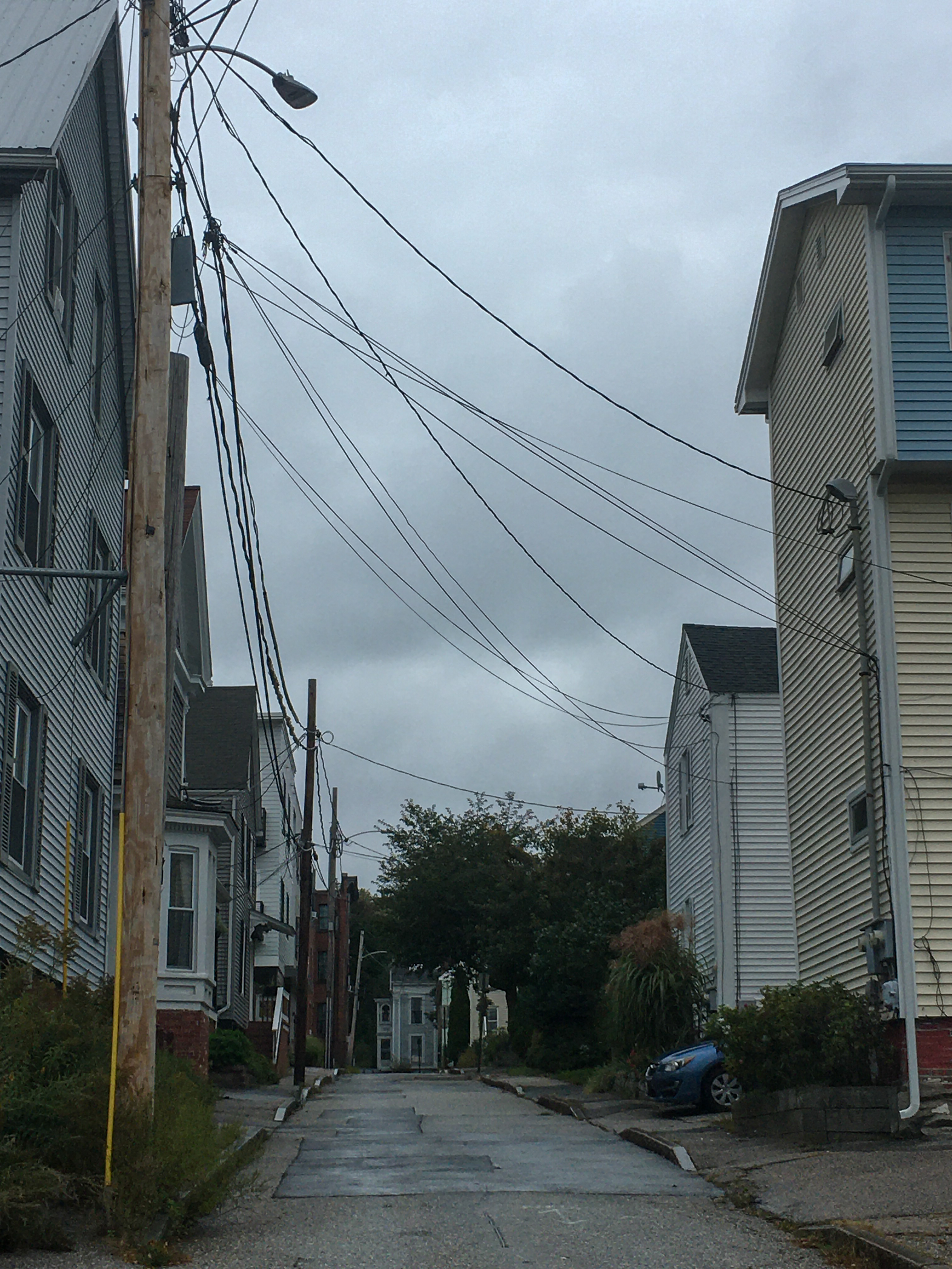 a narrow street with cloudy skys