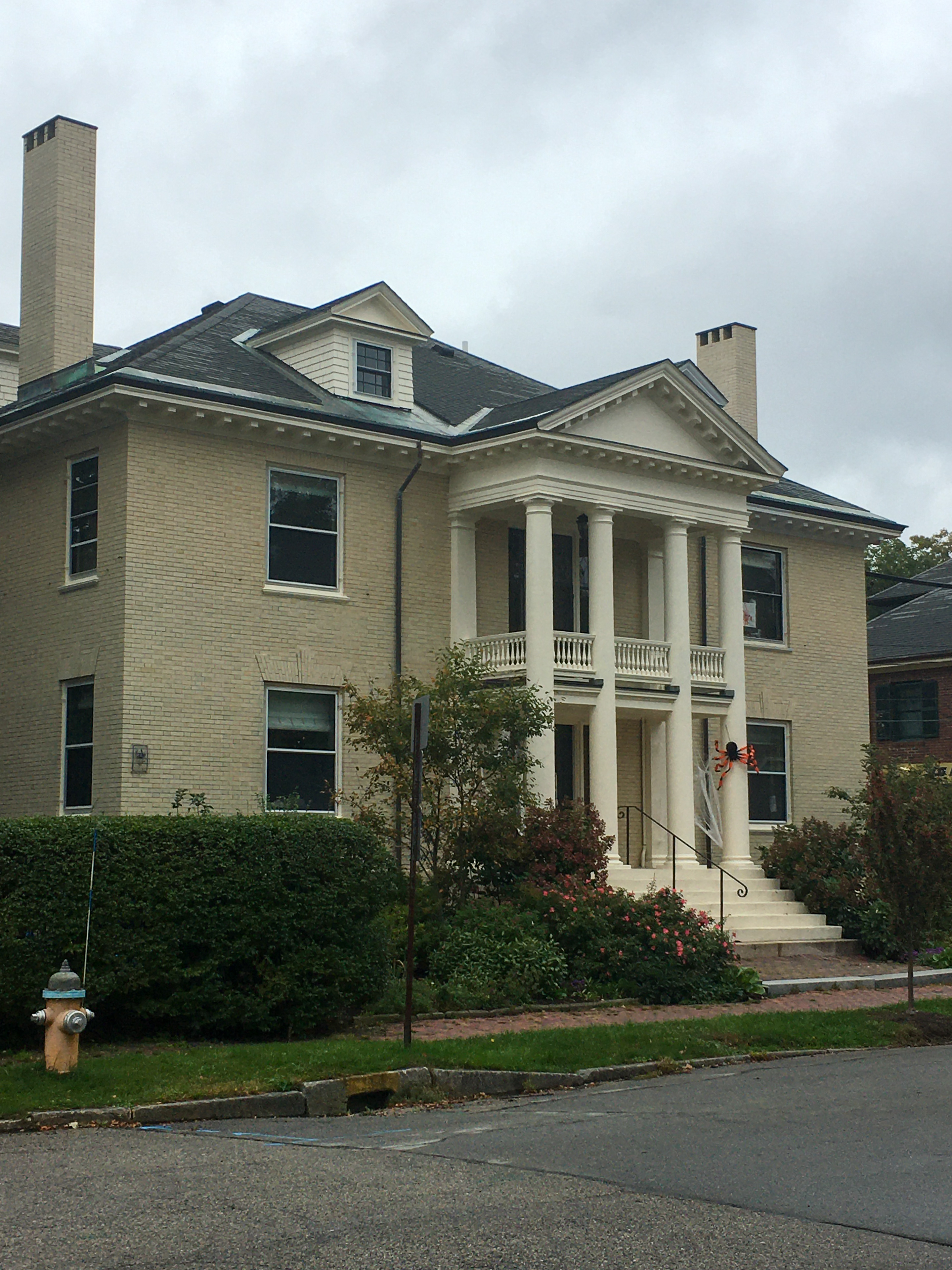large white brick house with a giant orange spider out front