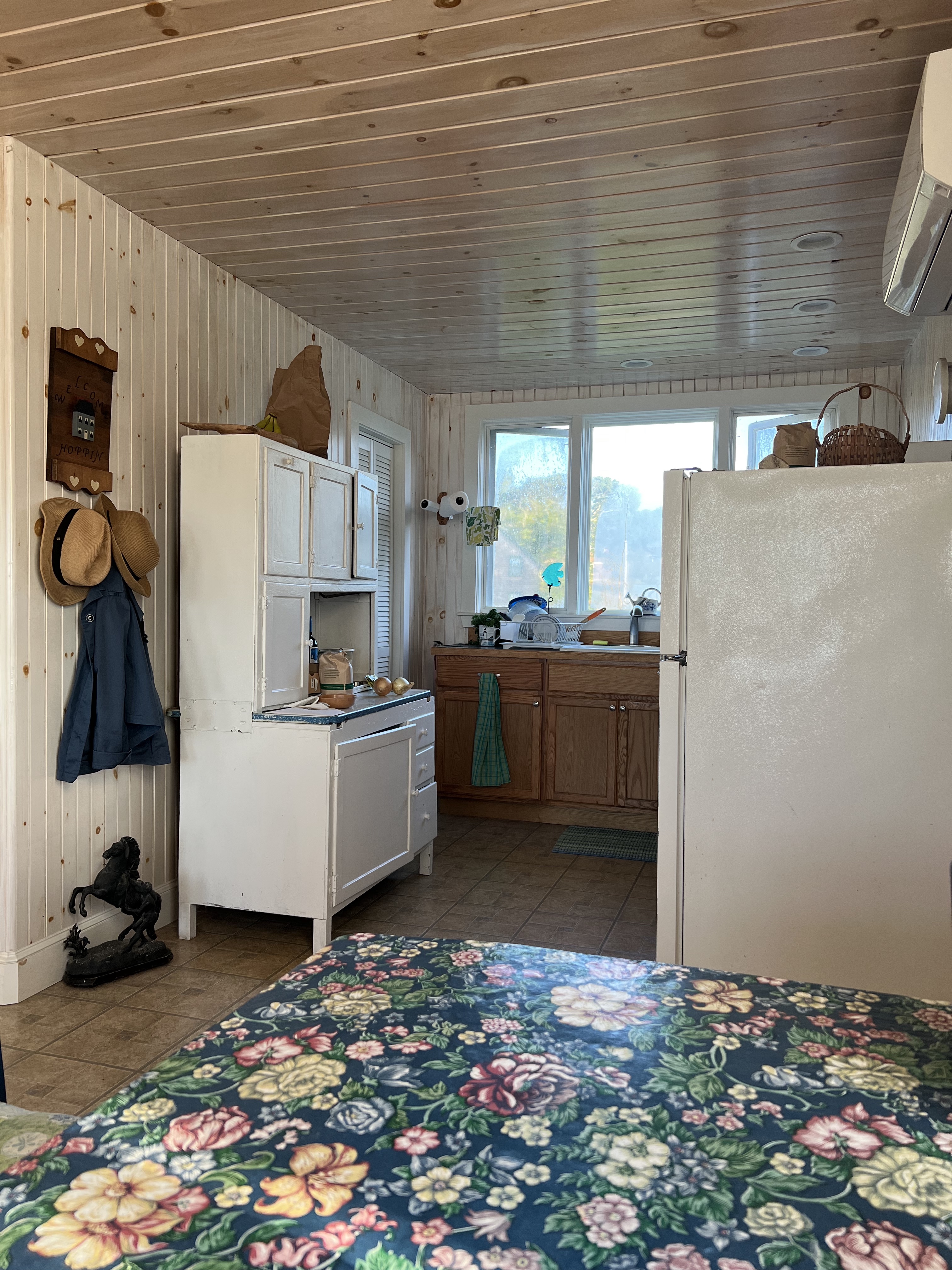 kitchen with table hutch and fridge with windows in the background