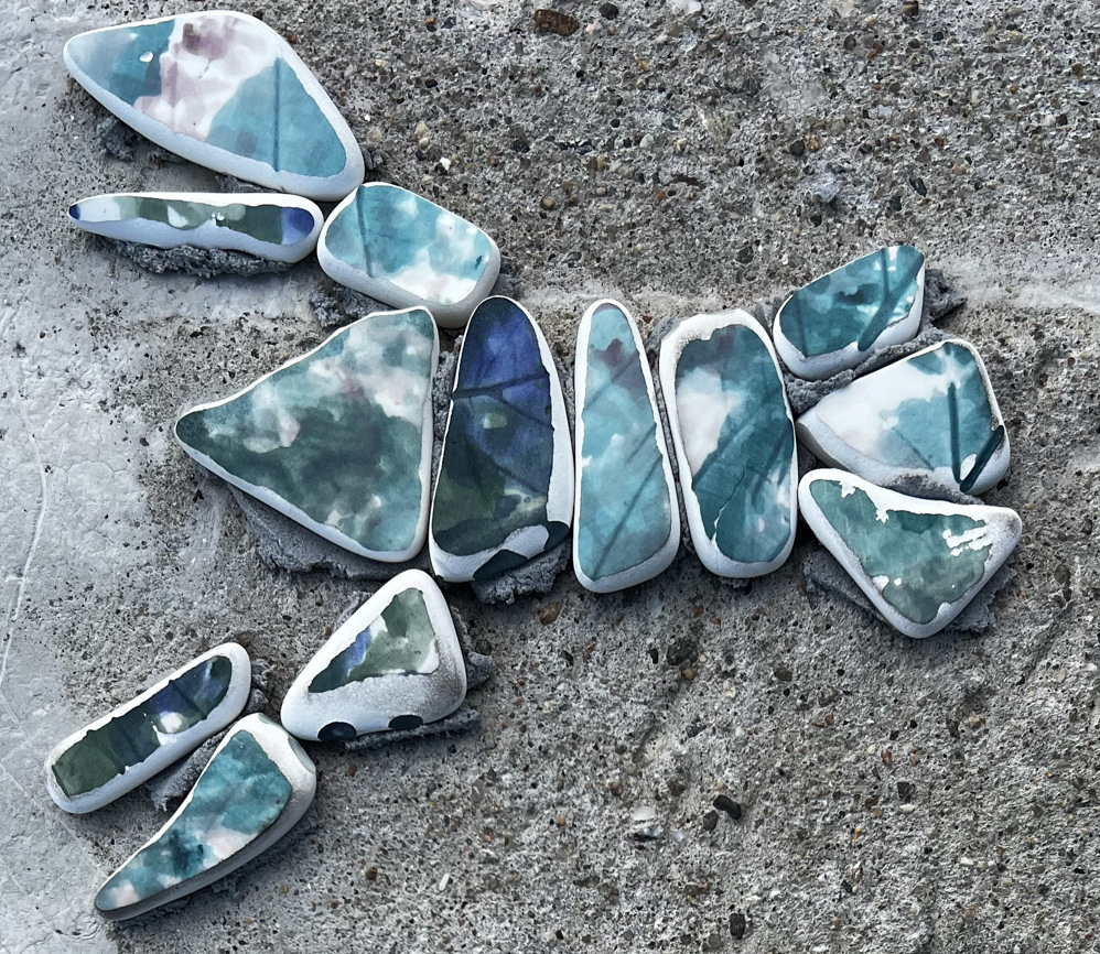 pieces of broken pottery ground down to soft shapes arranged beautifully. they are mostly different shades of blue.