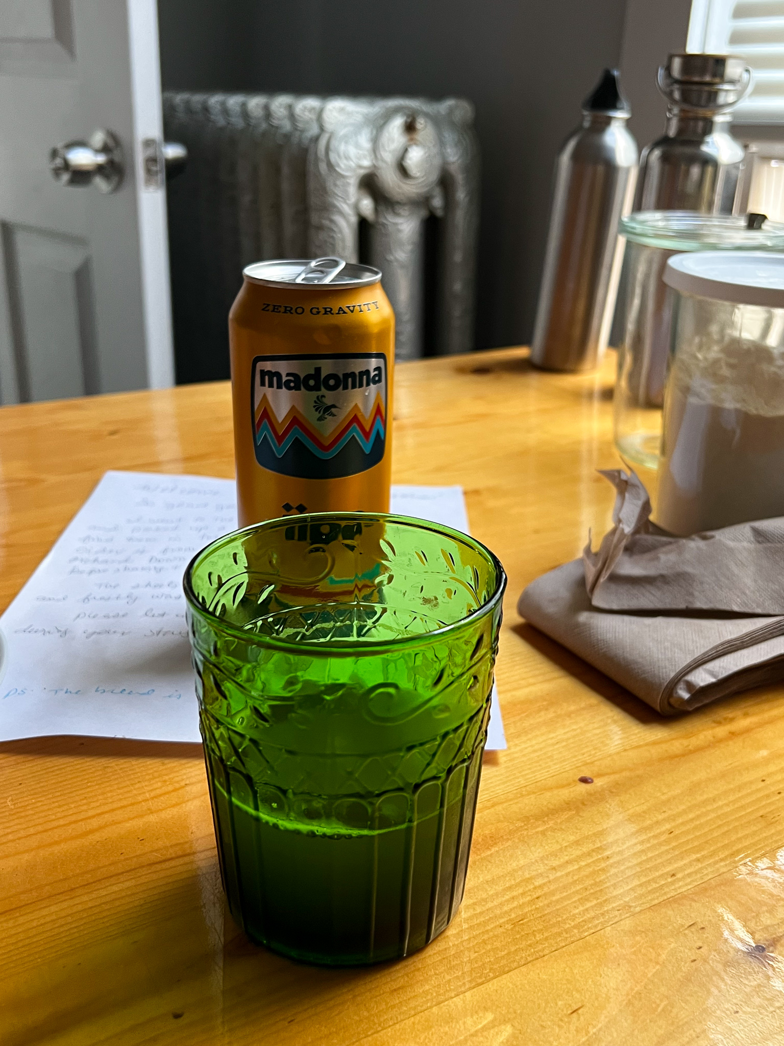 beer and a glass in messy kitchen