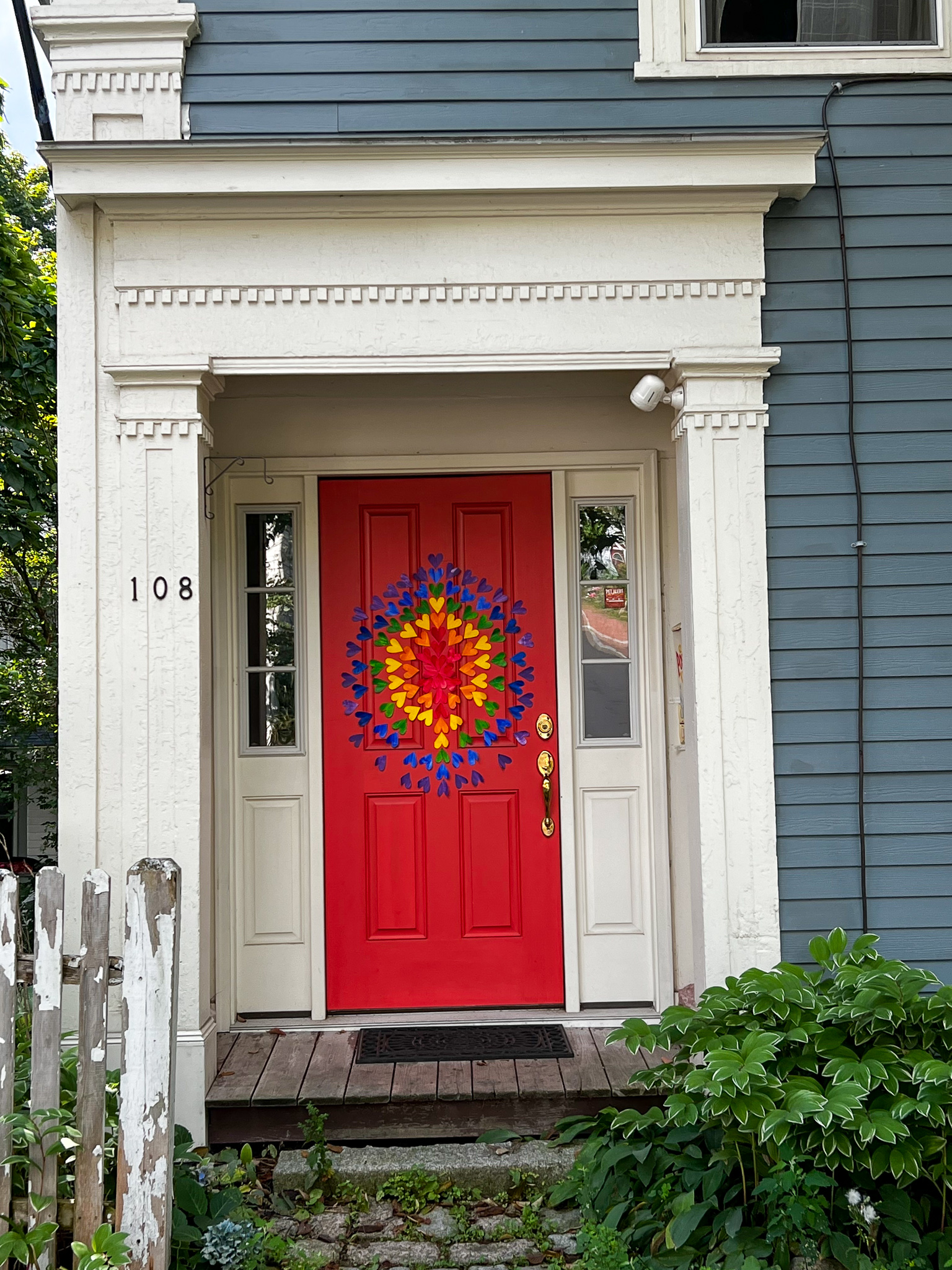 red door with rainbow of hearts in a circular design