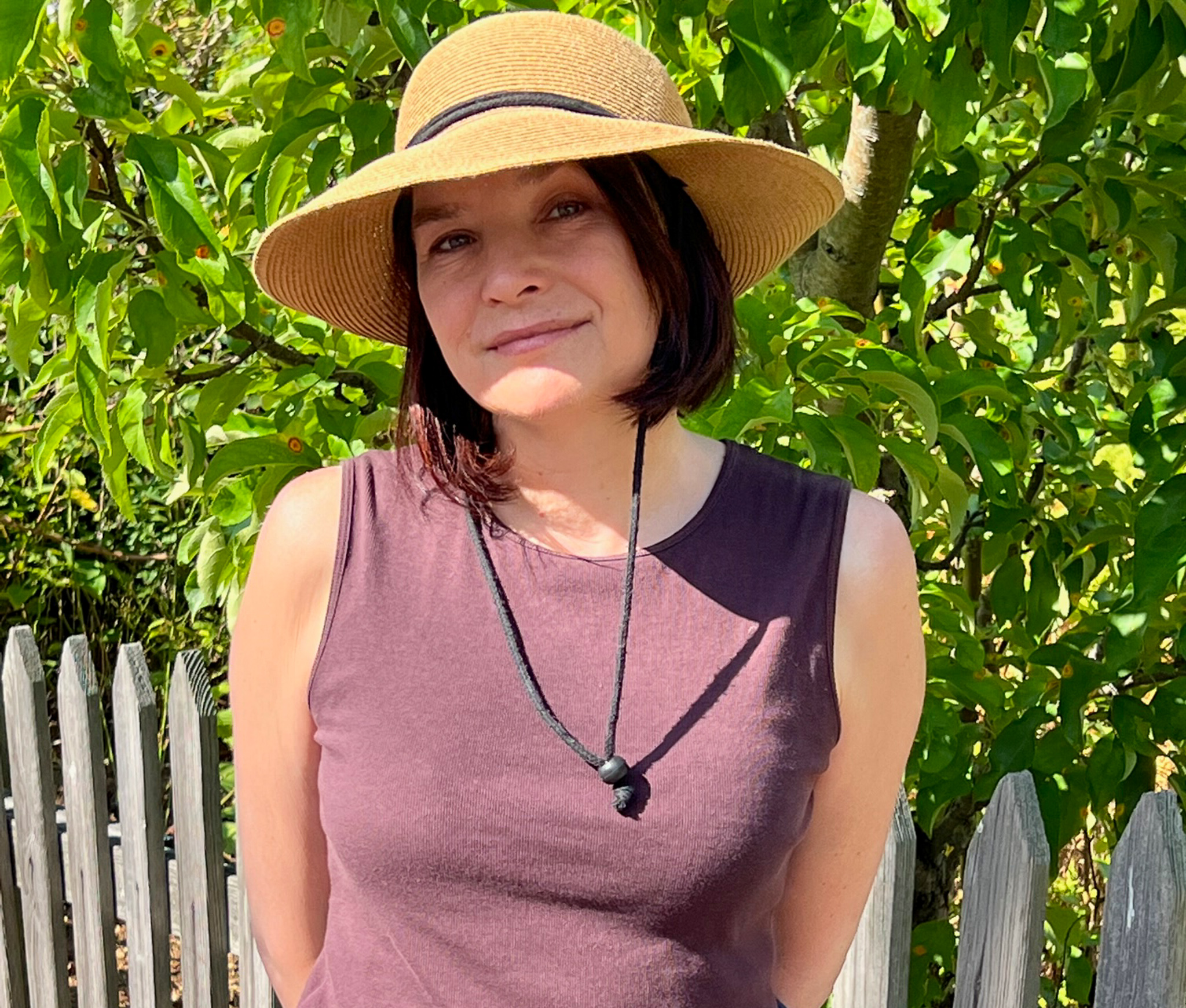 picture of a woman in a brown top with a sunhat 