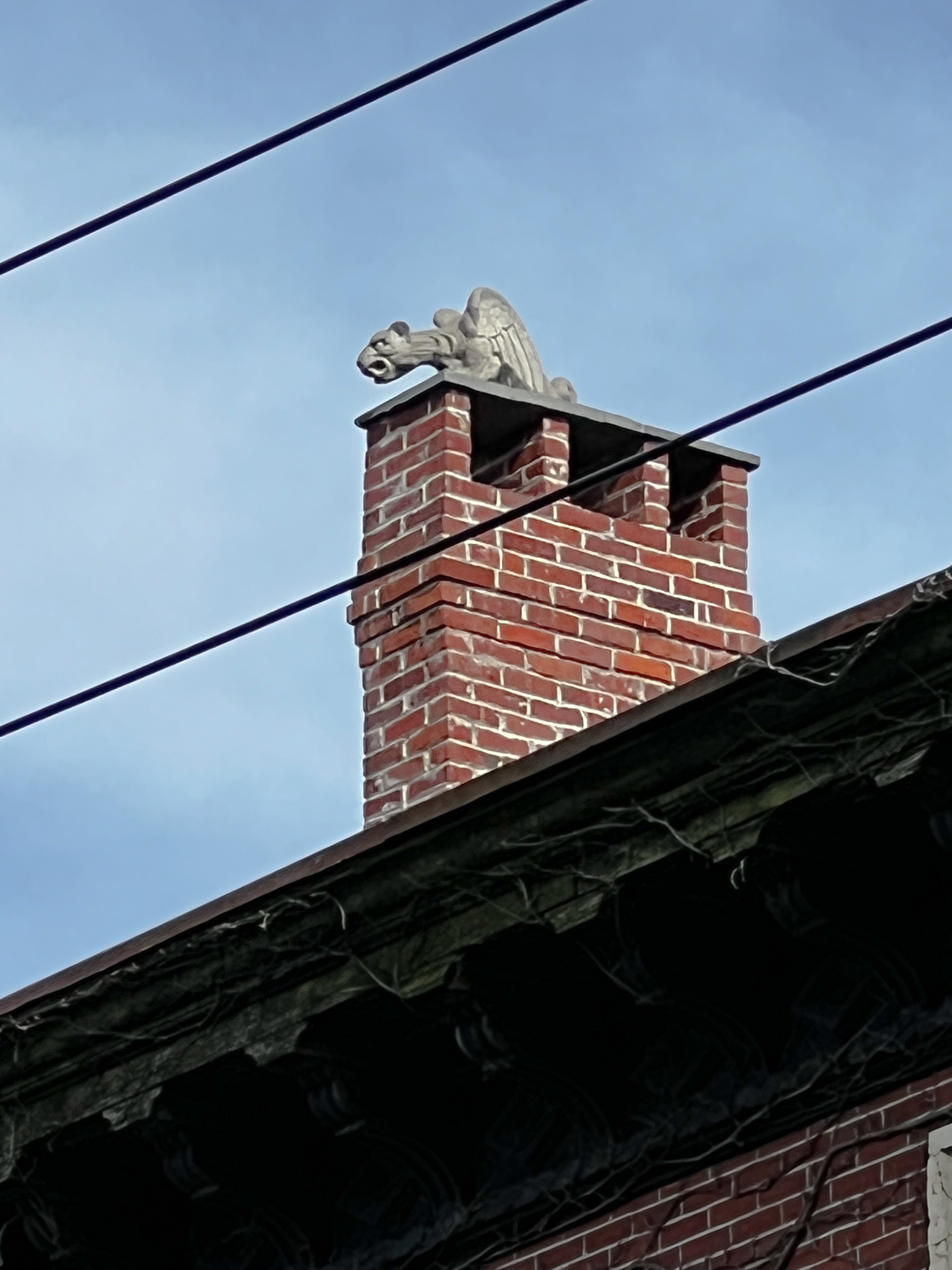 brick chimney with a great gargoyle on it