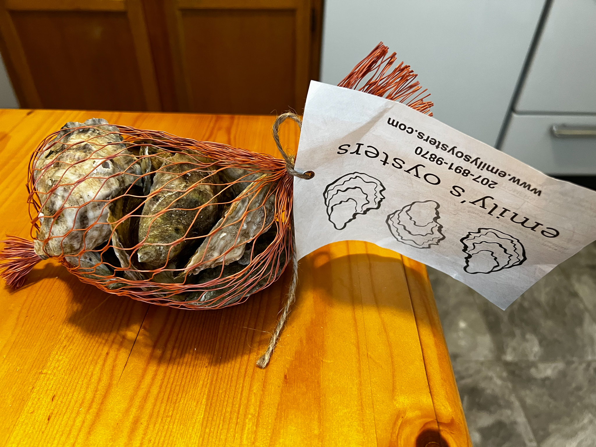 A bag of oysters with a tag that reads Emily's Oysters
