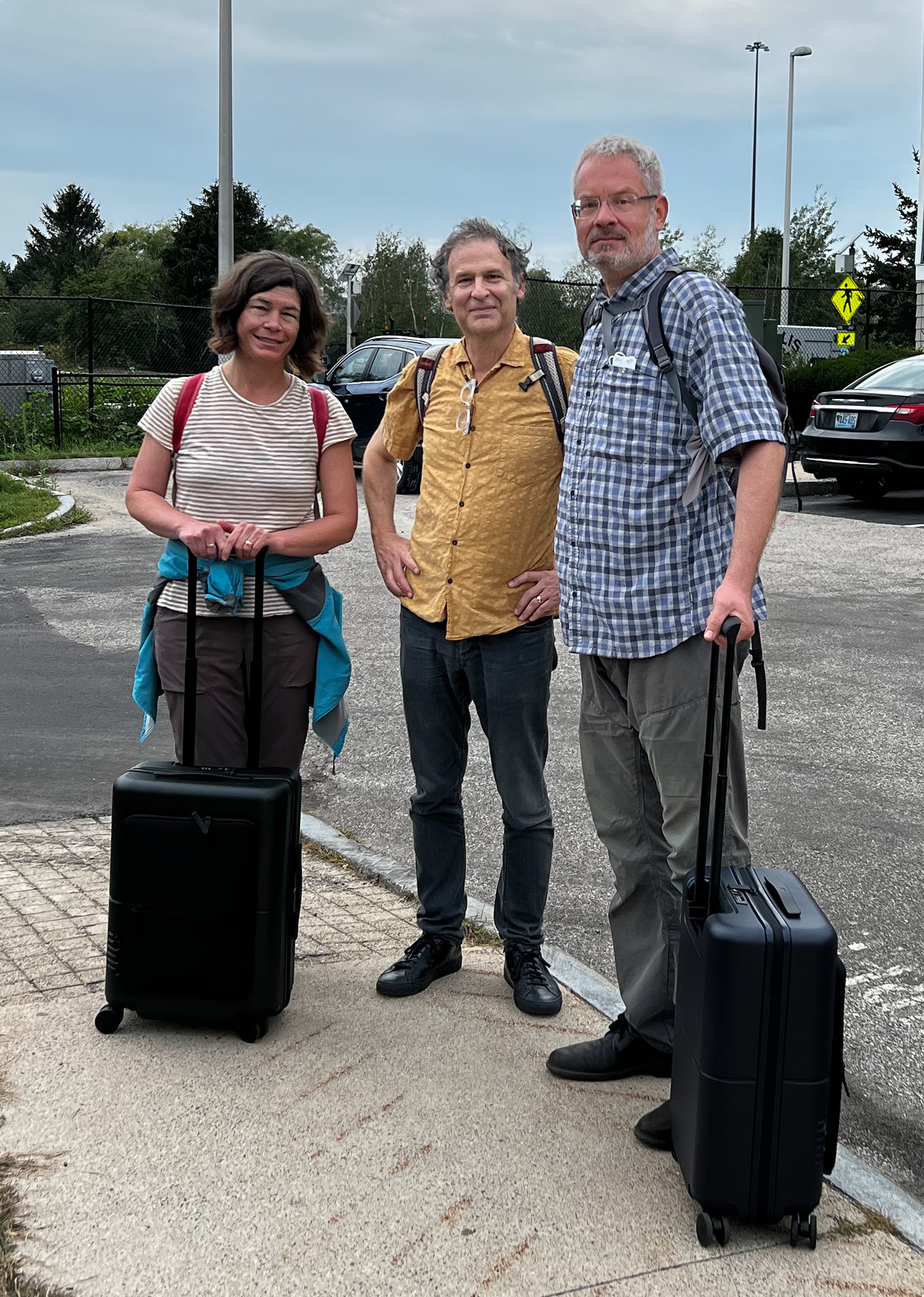 Two men and a woman with suitcases