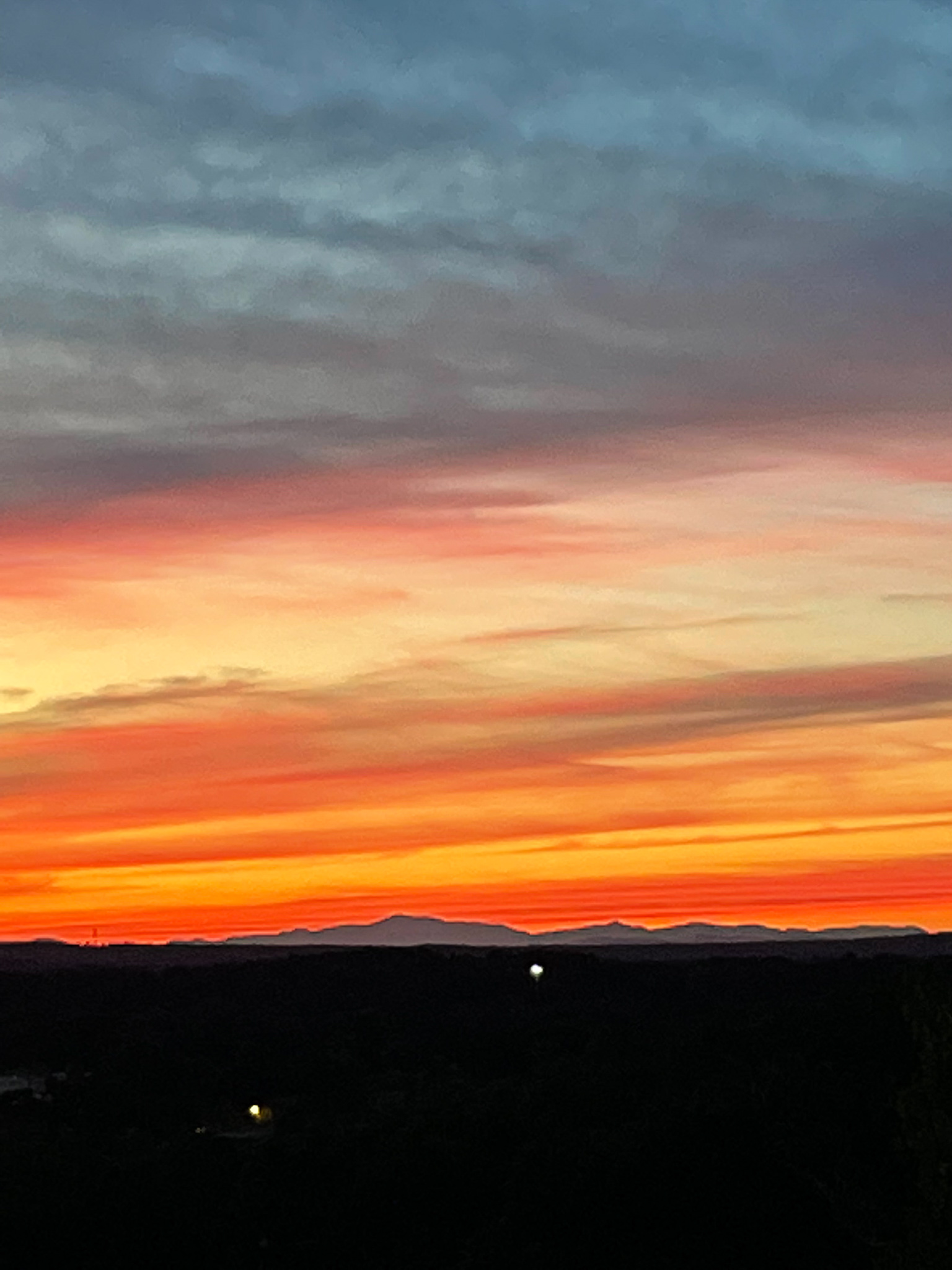 Sunset with dark land below