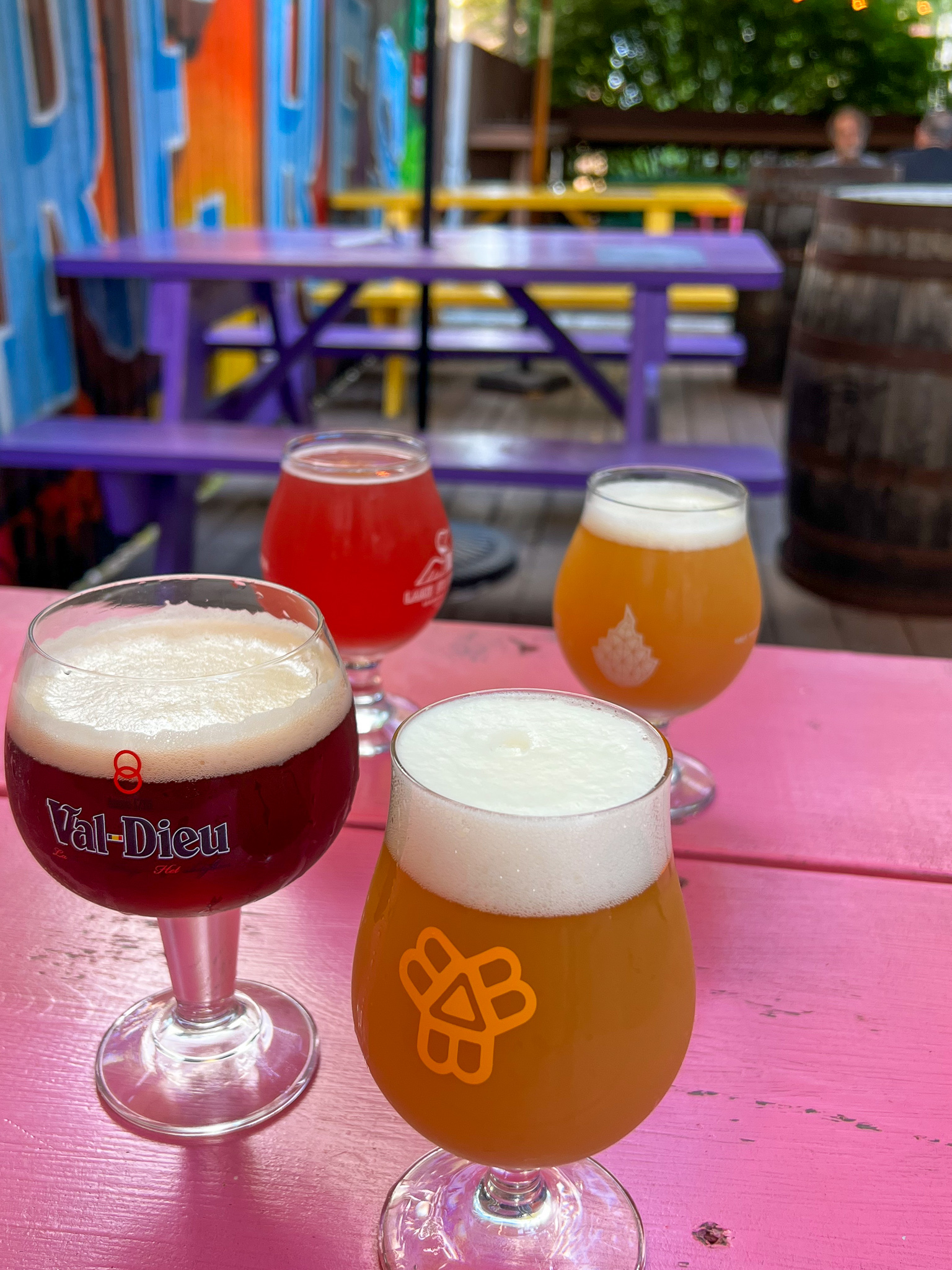 four glasses of different colored beer