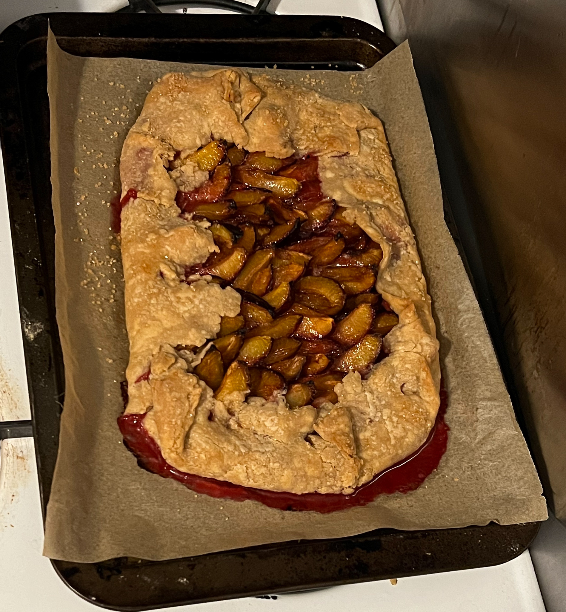 plum galette on a pan with parchment paper